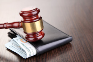 Gavel and money in wallet on wooden background
